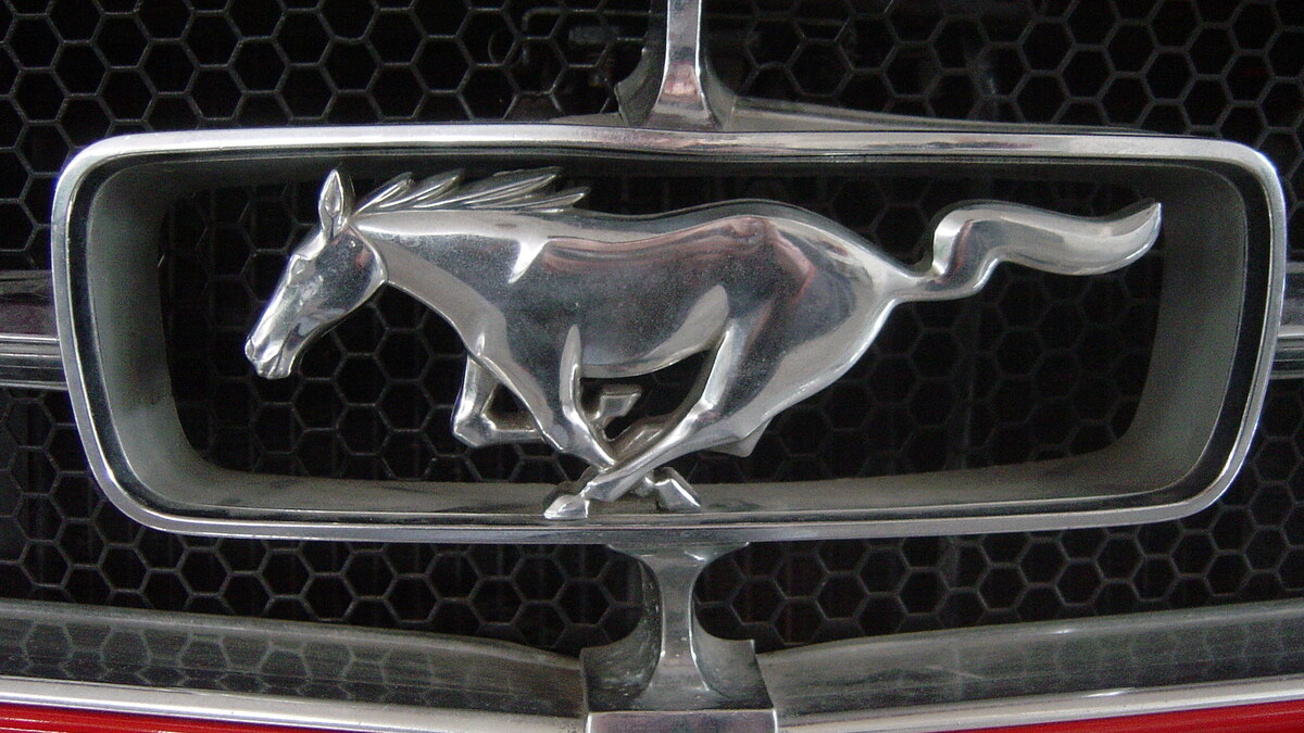 Logo cheval d’une Ford Mustang sur une calandre, pour illustrer les voitures avec emblème cheval