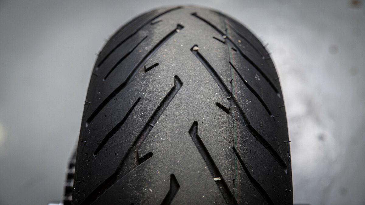 Bande de peur visible sur le pneu arrière d’une moto dans un atelier